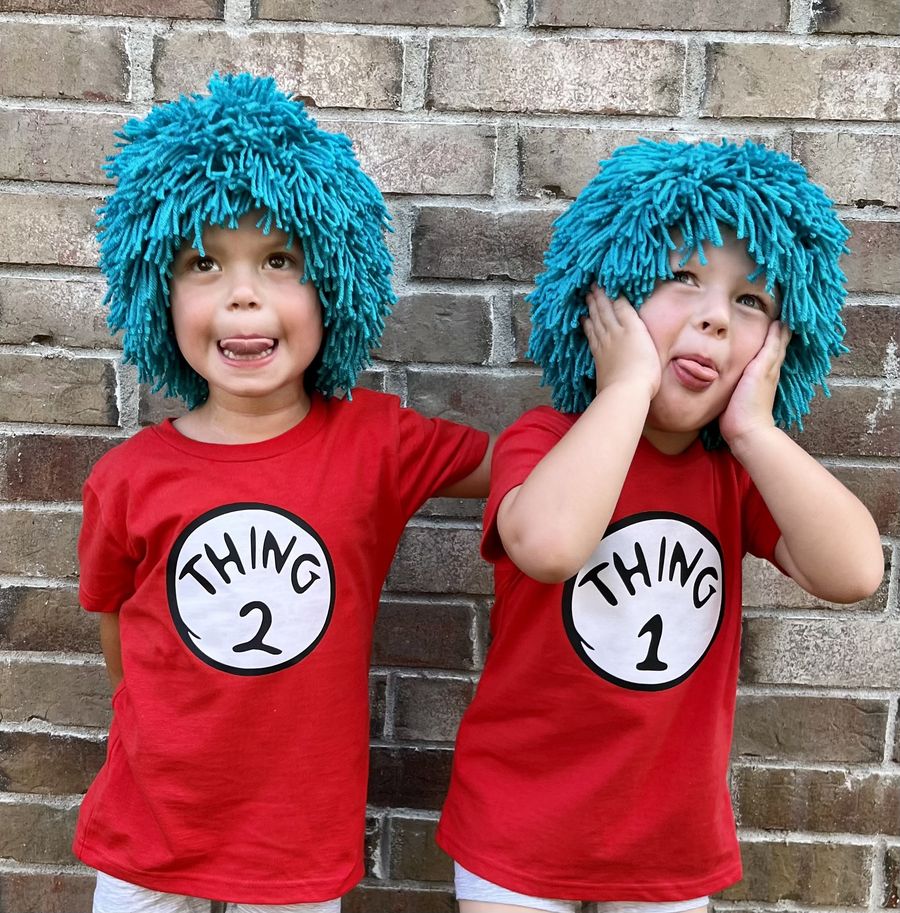 Two children wearing DIY Thing 1 and Thing 2 red shirts with blue afro wigs for Dr. Seuss Day